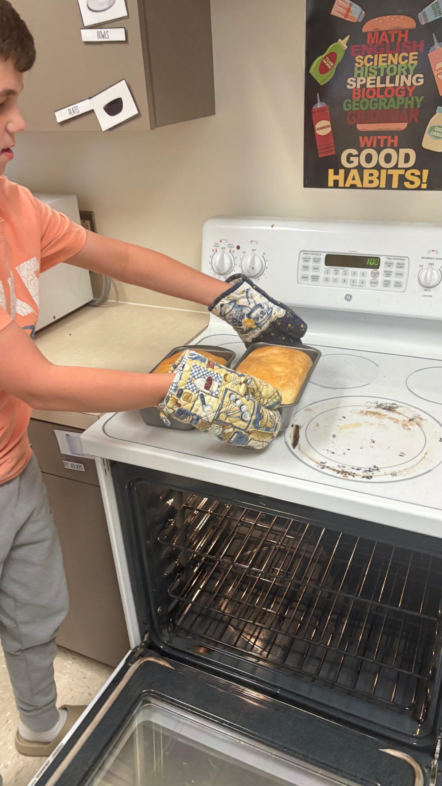 A baker holds a loaf of bread, setting it down on a stove.